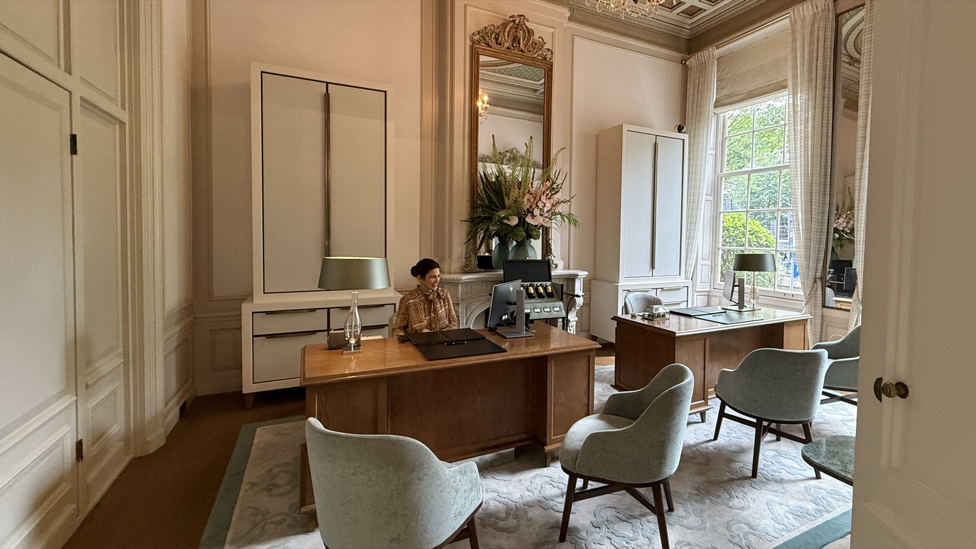 Residential-style check-in desk with a seated host at the Waldorf Astoria Amsterdam