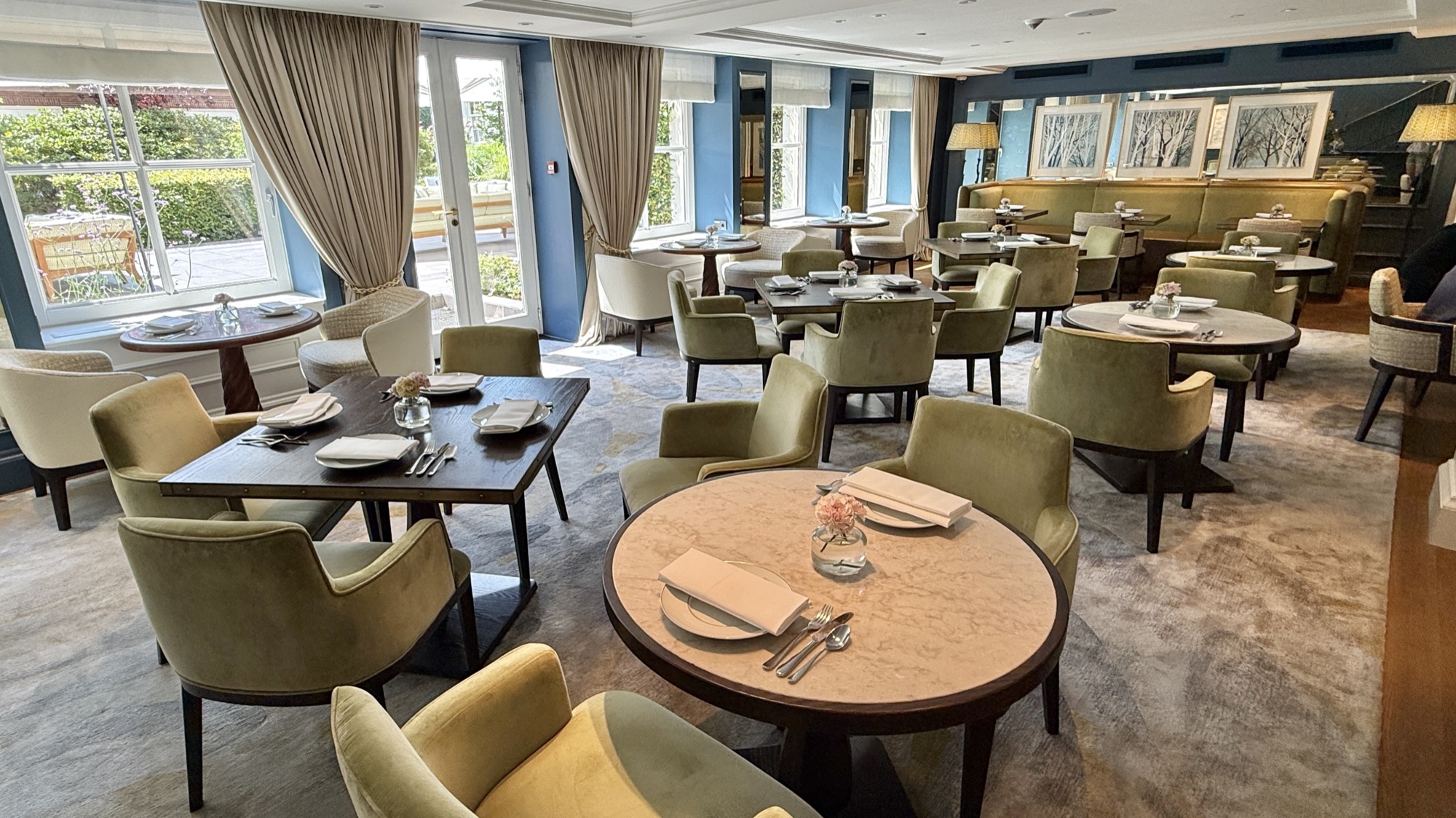 The Goldfinch Brasserie dining room on the Garden Level, with green chairs and garden views