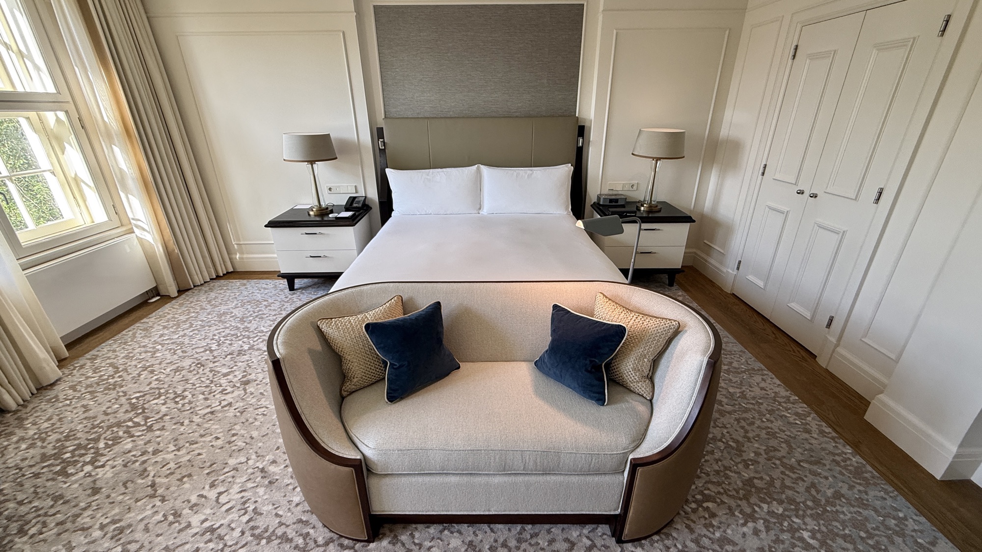 King bed with a chaise at its foot and navy accent cushions in the King Grand Premier room