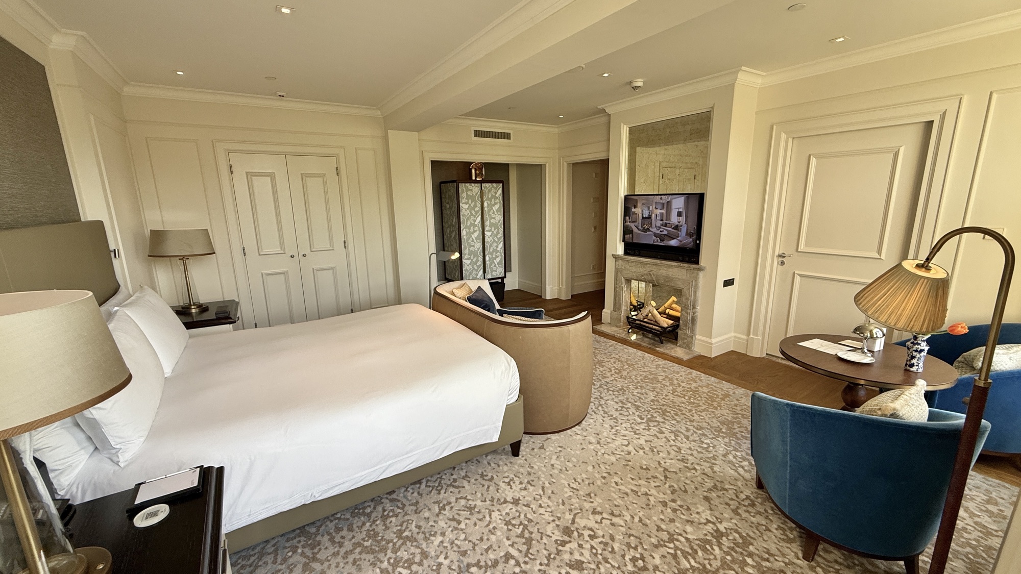 Wider view of the King Grand Premier with Canal View room showing the bed, seating, and fireplace area