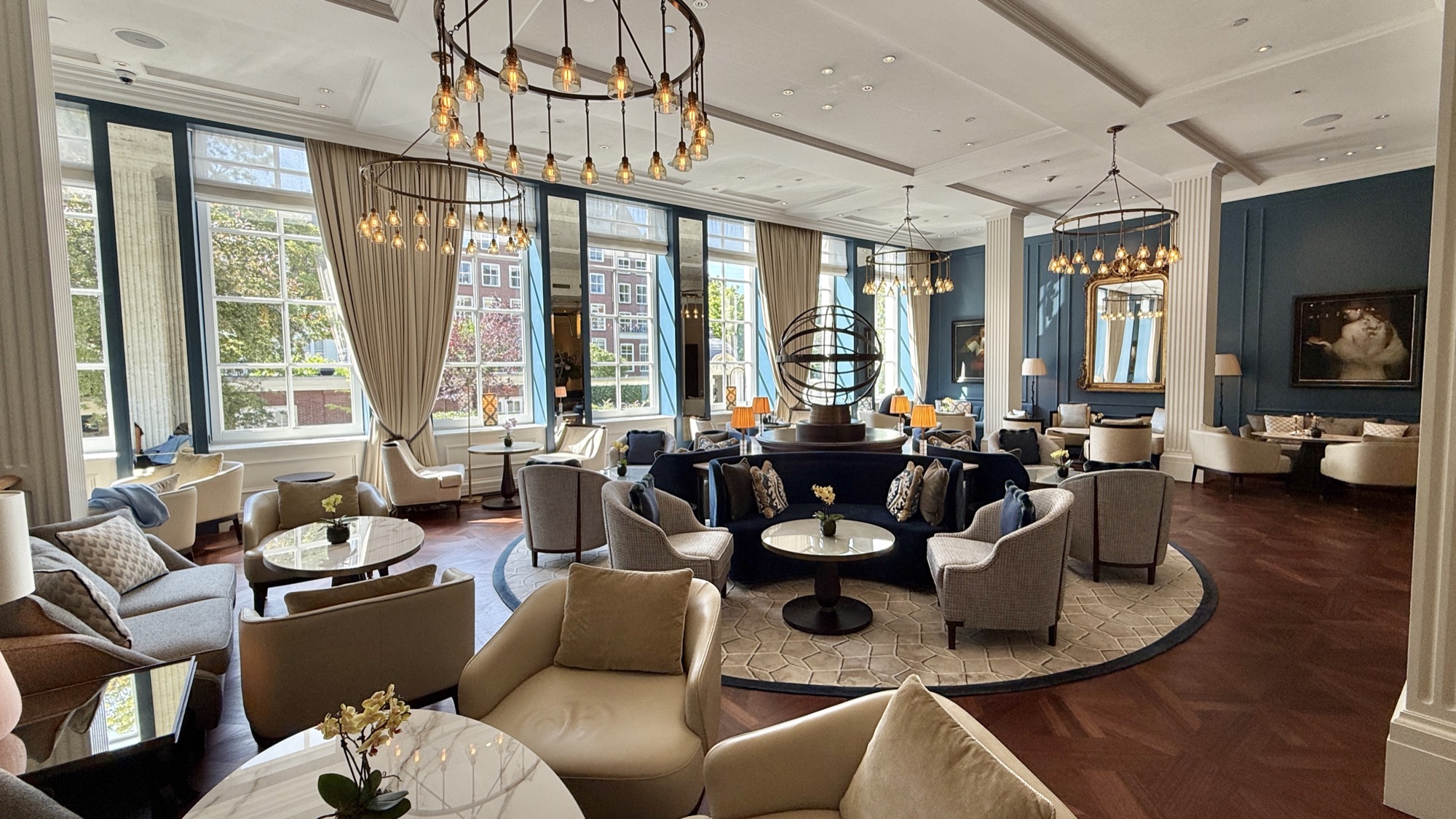 The Peacock Lounge in daylight, with cream armchairs, columns, and canal-facing windows