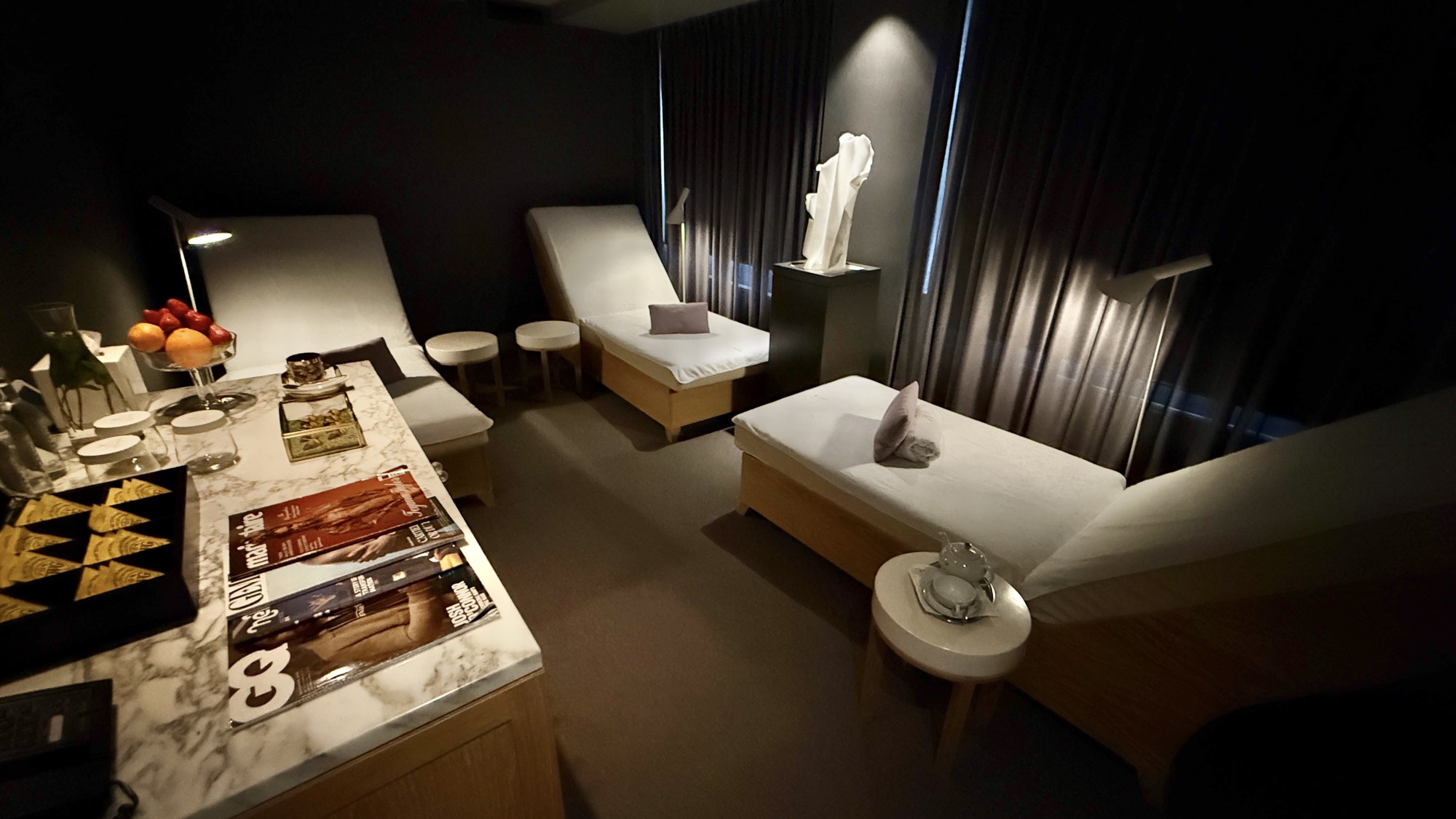Spa relaxation lounge with loungers and a marble refreshments table