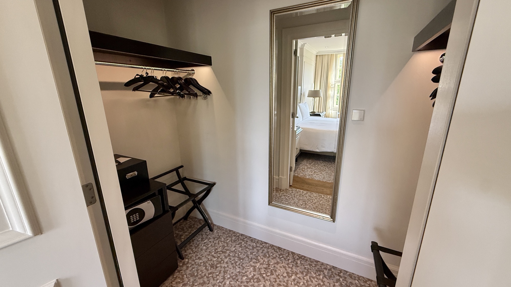 Walk-in closet with a dressing mirror and luggage rack in the King Grand Premier room